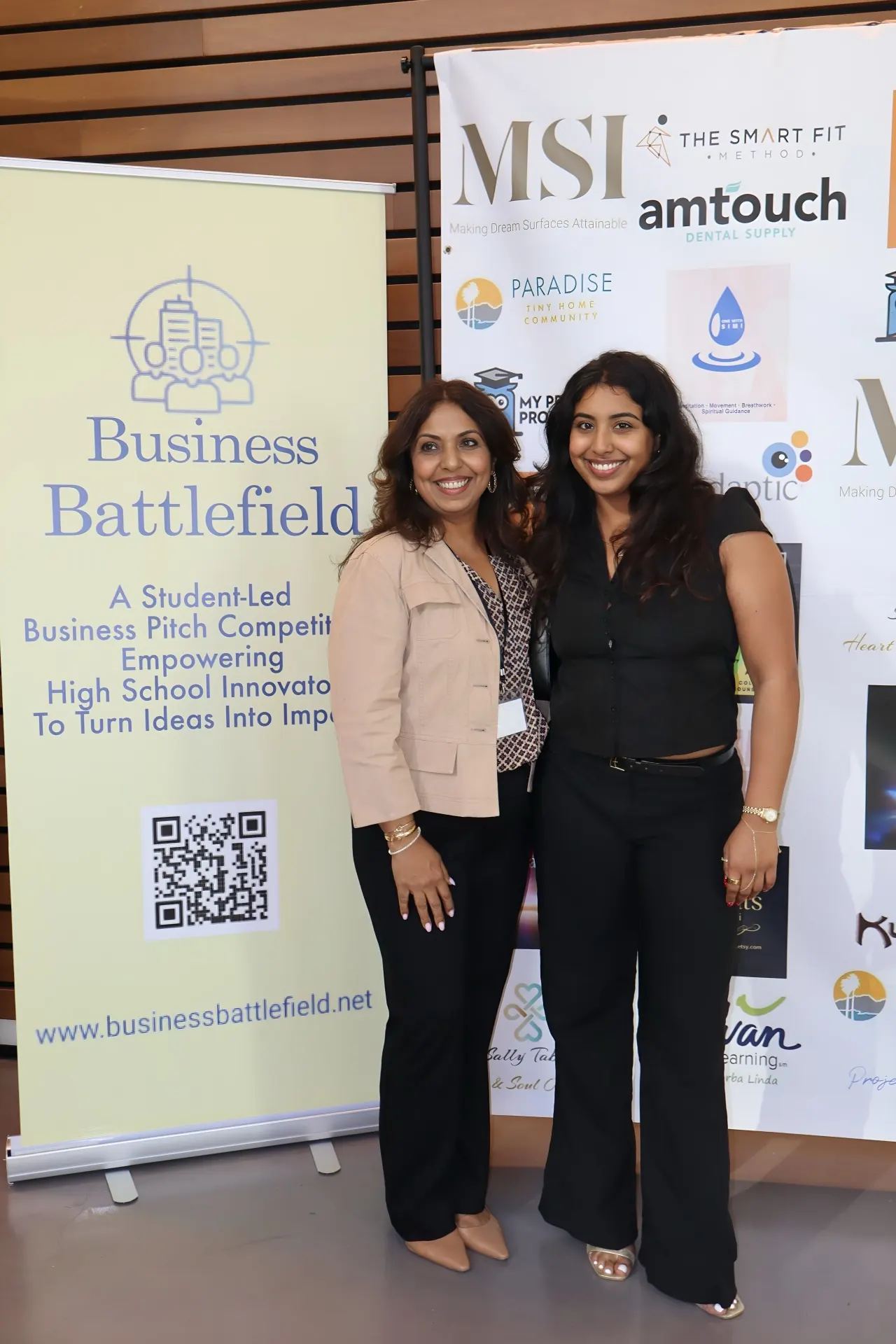 Founders representing Business Battlefield in front of the program banner.